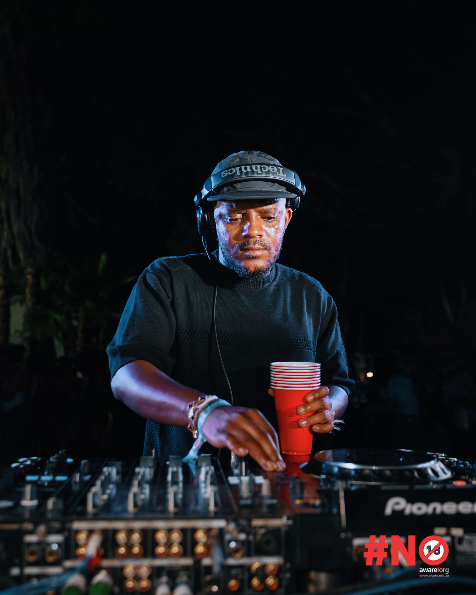 DJ performing on stage with dramatic lighting