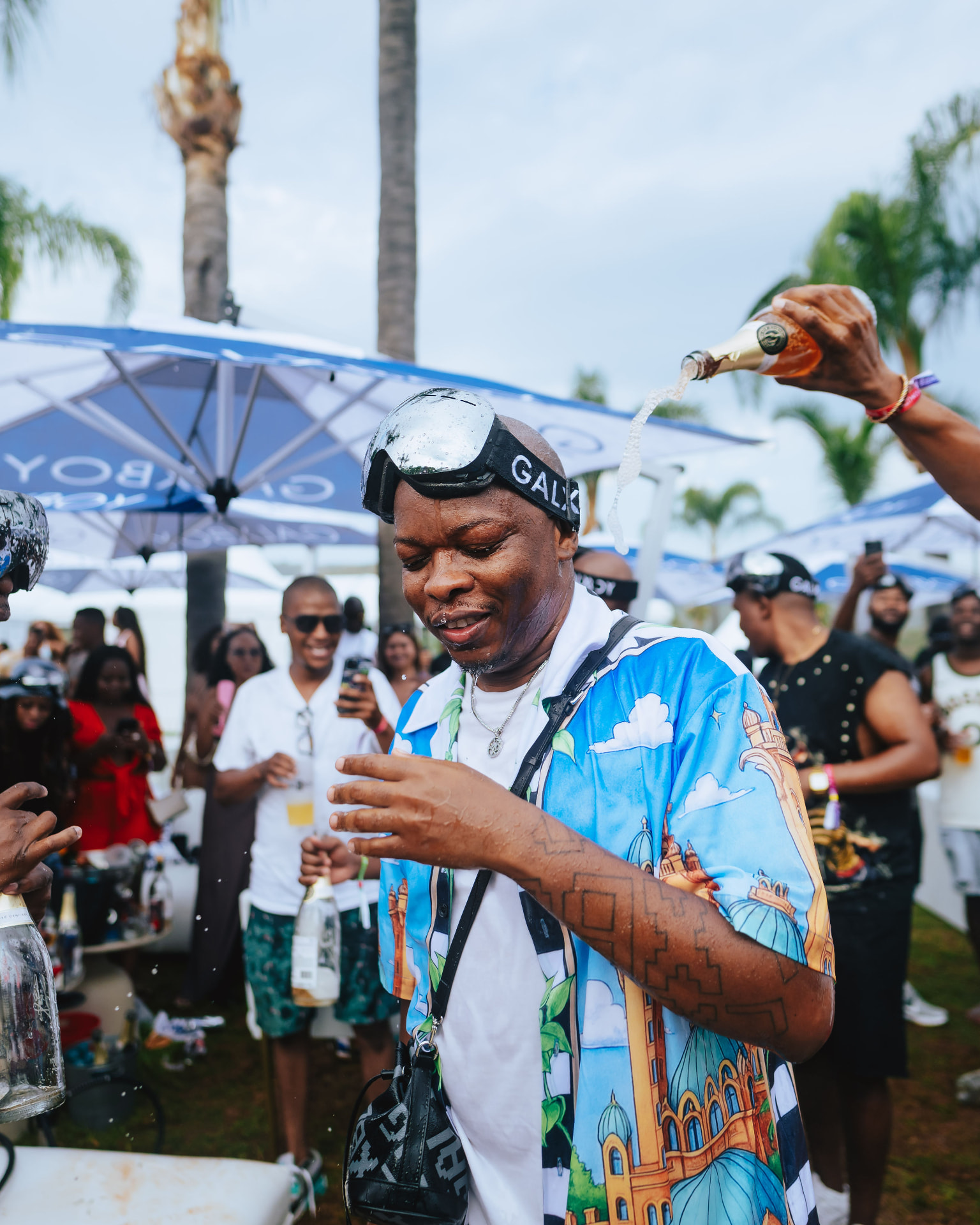 Champagne being poured over a guest at the outdoor party