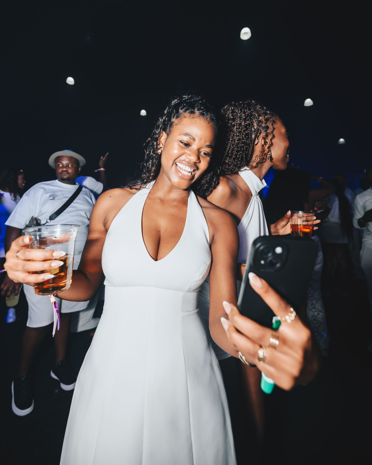 Two guests in white laughing together at the night party