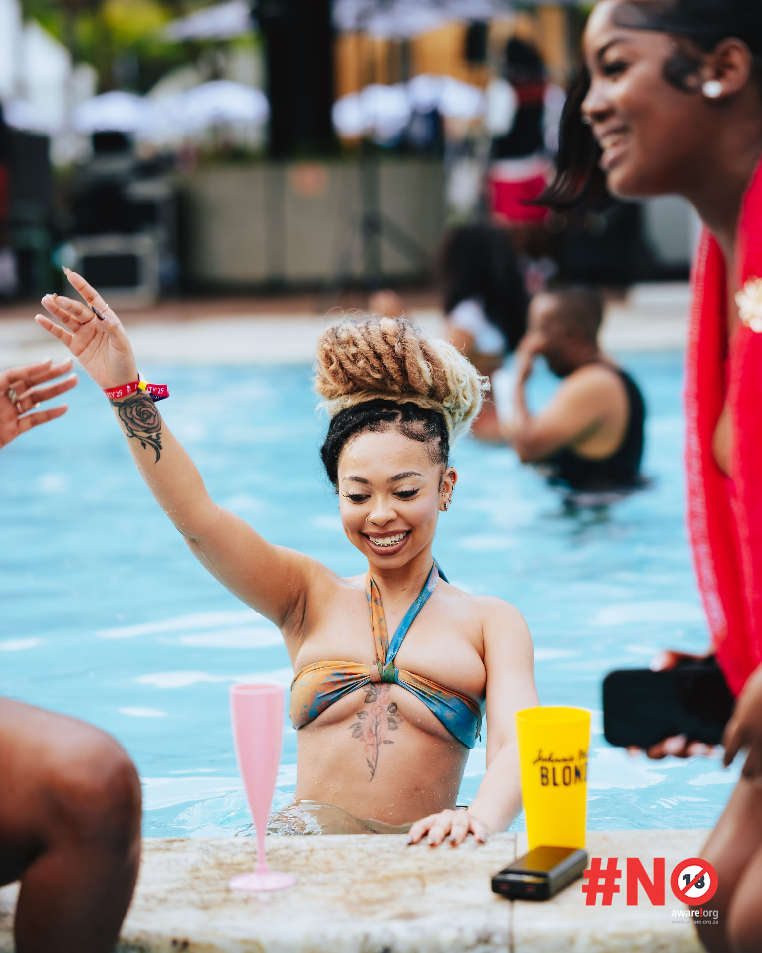 Guest relaxing at the pool edge with a cocktail