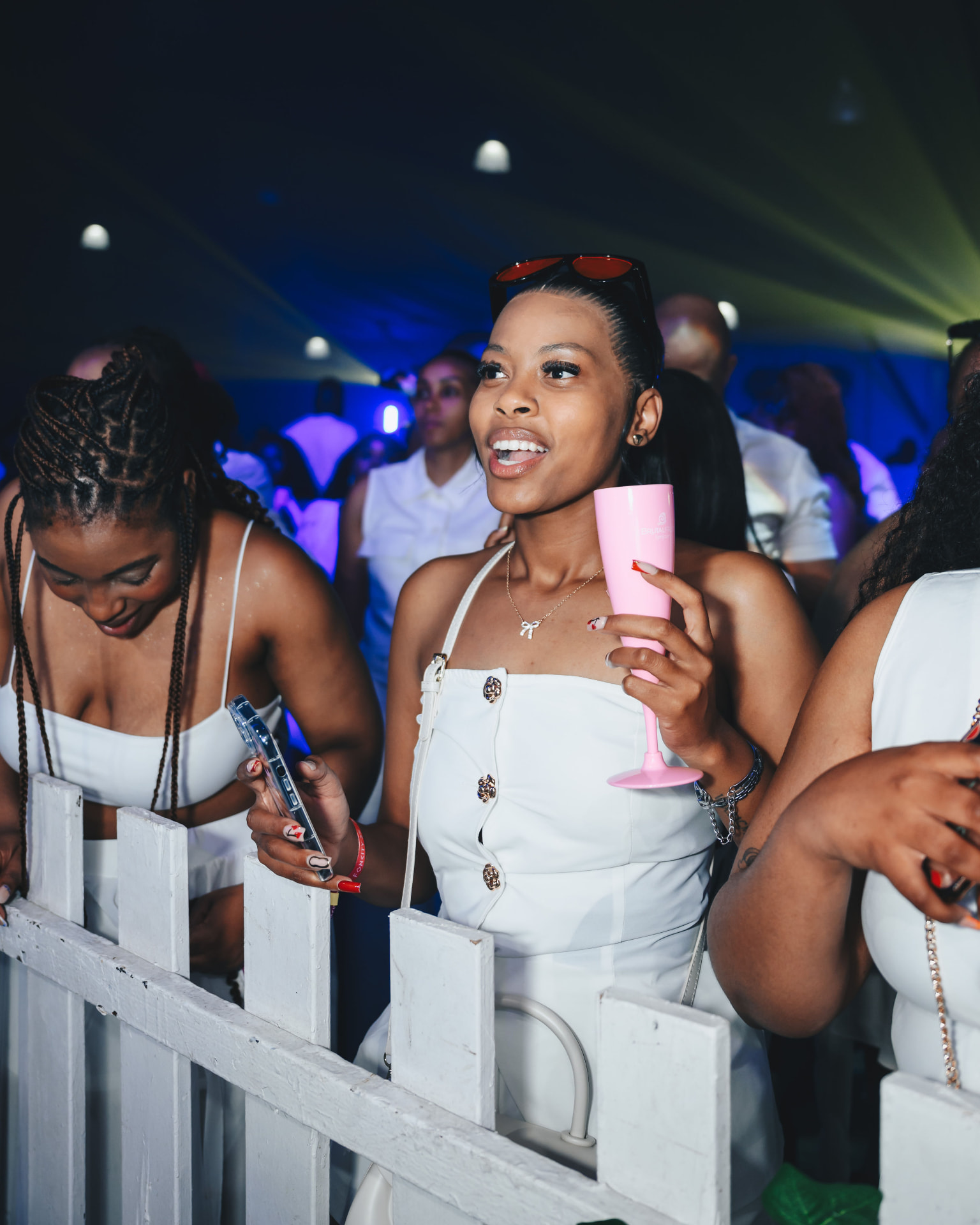 Guest in white holding a pink cup at the all-white party
